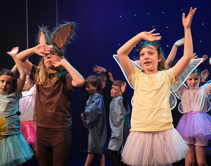 Children dancing in Y Goedwig Hud story by Mared Llywelyn