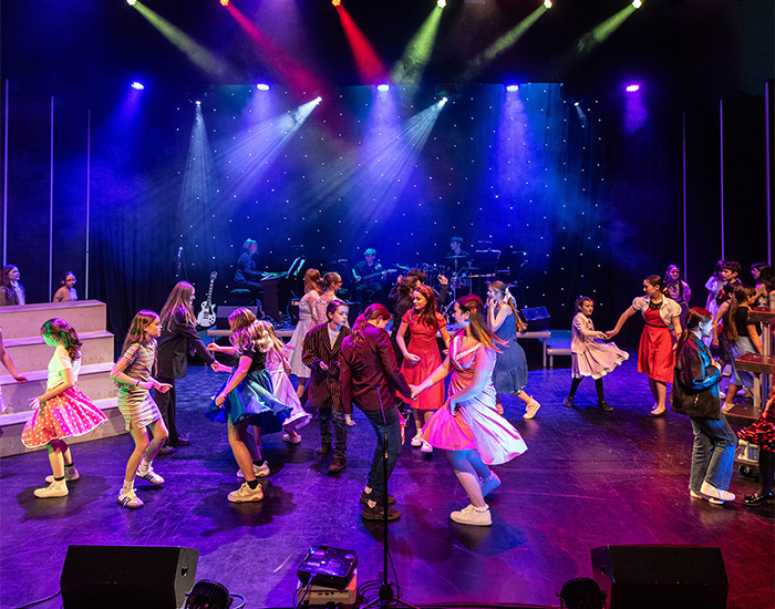 Children dancing on the stage while perfoming a scene in Gris