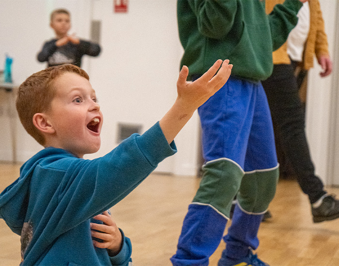 A chil singing with his arms in they air